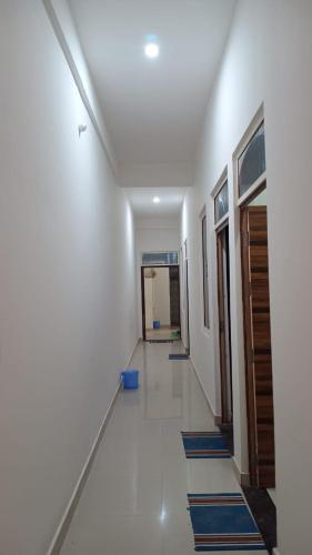 un corridoio con tappetini blu sul pavimento di un edificio di Geeta Dham a Vrindāvan
