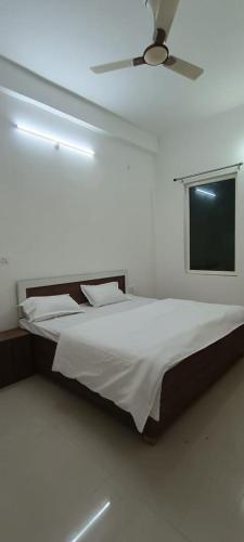 Geeta Dham في فريندافان: غرفة نوم مع سرير ومروحة سقف