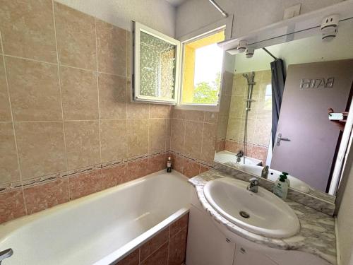 une salle de bain avec un lavabo et une baignoire dans l'établissement Maison de la Plage N°4, au Grau-dʼAgde
