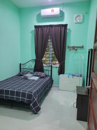 a bedroom with a bed with blue walls and a window at Homestay Haji Noor in Tanah Merah