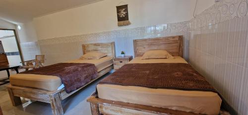 two twin beds in a room with sidx sidx sidx sidx at FATINN'S surf Apartements in Airsatang