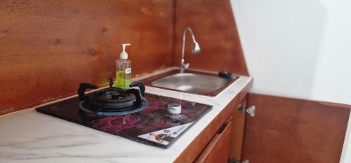 a kitchen counter with a sink and a pot on a stove at FATINN'S surf Apartements in Airsatang