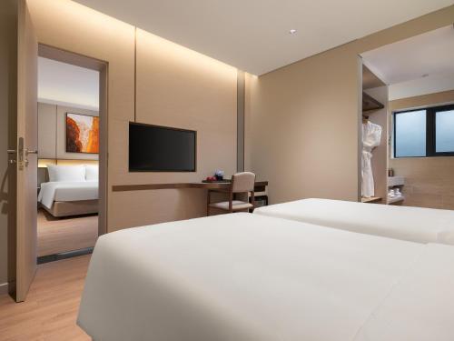 a hotel room with two beds and a television at CLASSYC Hotel in Hanoi