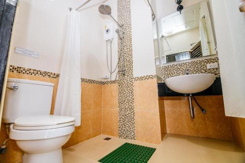 een badkamer met een toilet, een wastafel en een douche bij The one boutique hotel in Satun