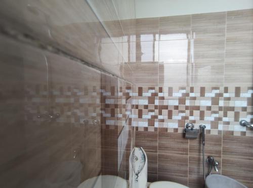 uma casa de banho com um WC e uma cabina de duche em vidro. em Marina Residency em Muzaffarabad