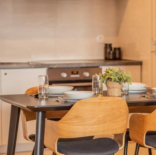 a kitchen with a table with plates and glasses on it at Wonderful Apartment near City Mall in Podgorica