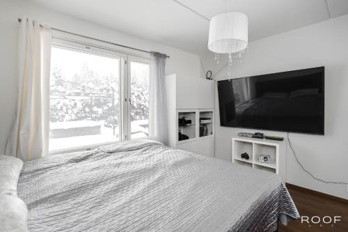 a bedroom with a bed and a large window at Cozy Holiday Home with Outside Jacuzzi in Espoo