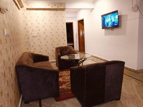 a living room with two chairs and a table and a television at Great escape in Lucknow