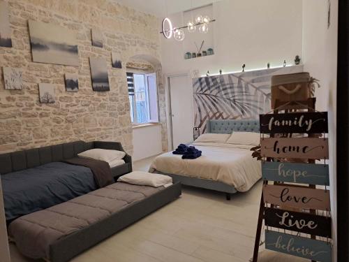 a room with two beds and a couch in it at Maison Divino in Trani