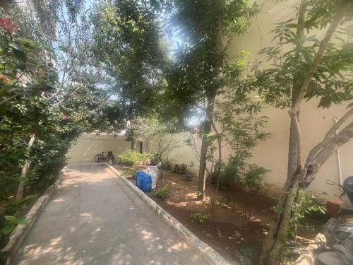 an alley way with trees and a building at S V Homes in Kumbakonam