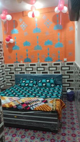 a bed in a room with an orange wall at Kanha ji Divine dham 89799Vrindavan12972, free pick up also taxi and Activa rent in Mathura