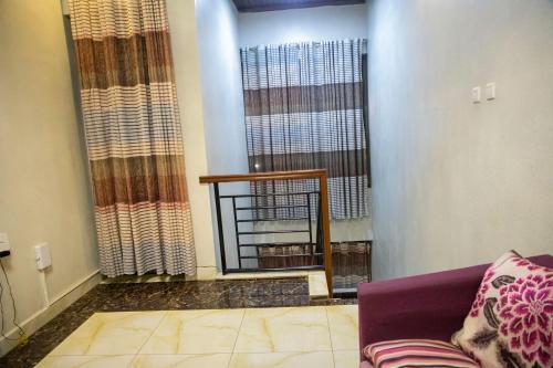 uma sala de estar com um sofá roxo e uma janela em LEED Homes em Kigali