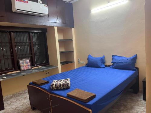 a bedroom with a bed with blue sheets and blue pillows at S V Homes in Kumbakonam