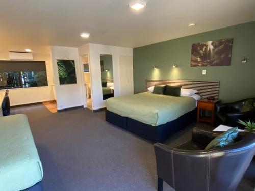 a hotel room with a bed and a couch at Commodore Motel in Dunedin