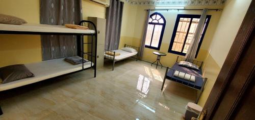 a room with three bunk beds and a window at Viva Hostel Group Nizwa in Nizwa