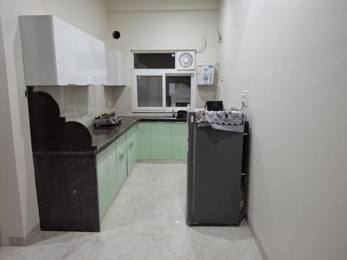 uma cozinha com um frigorífico preto e um micro-ondas em 636 Kedia Kothhi em Jaipur