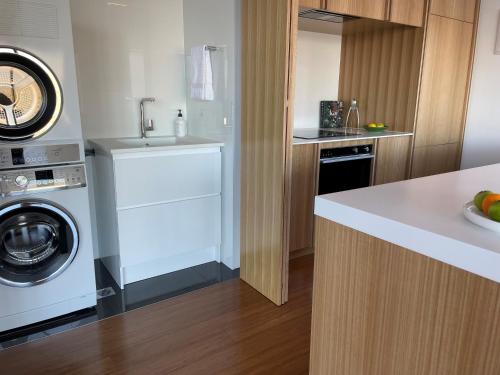 a kitchen with a washing machine and a washer and dryer at No.8 Queenstown in Queenstown