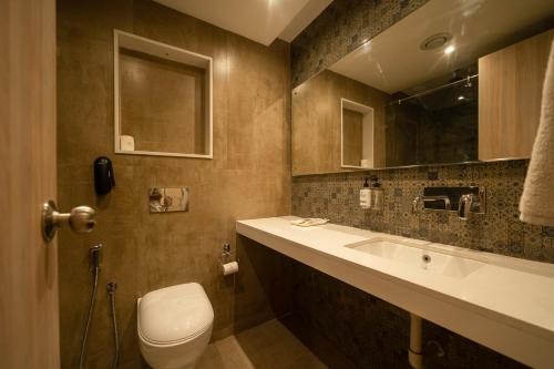 y baño con aseo, lavabo y espejo. en Sparrow Hotels managed by Siara, en Alwar