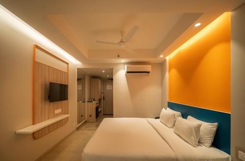 a hotel room with a bed and a television at Sparrow Hotel Managed by Siara Sariska Alwar in Alwar