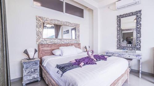 1 dormitorio con espejo grande y cama en Waenis Sunset View Hotel and Restaurant, Amed, Bali, en Amed