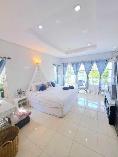 a large bedroom with a large bed and a tv at Prathana Garden Beach Resort in Hua Hin