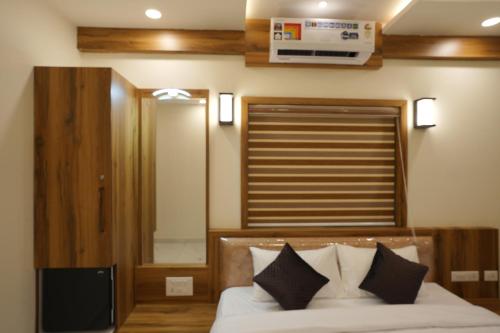 a bedroom with a bed and a window and a mirror at Mesteria Inn Wayanad in Wayanad