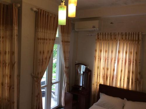 a bedroom with a bed and a window with curtains at BB homestay in Thôn Tiên Nộn