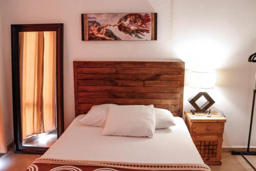 a bedroom with a bed with a wooden headboard at Casa Laguna , Lagoon House in Veracruz