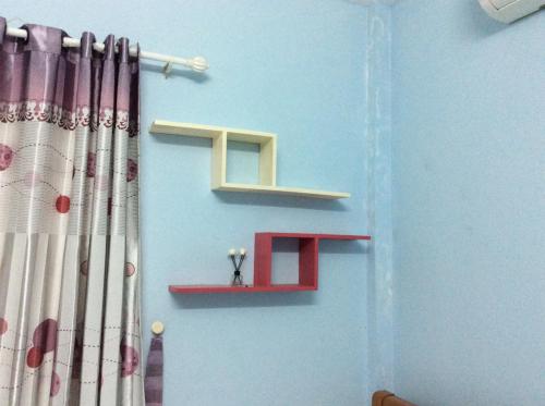 a room with a wall with a letter h and shelves at BB homestay in Thôn Tiên Nộn