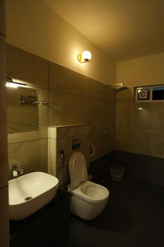 a bathroom with a white toilet and a sink at Mesteria Inn Wayanad in Wayanad