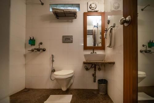 a bathroom with a toilet and a sink at Sparrow Hotel Managed by Siara Sariska Alwar in Alwar