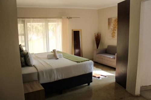 1 dormitorio con 1 cama y 1 sofá en Biko's Villa, en Hekpoort