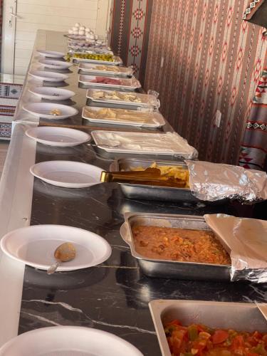 a long buffet line with plates of food on at Wadi Rum stargazing camp in Wadi Rum