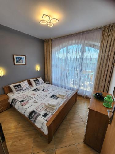 a bedroom with a large bed and a window at Golden Dreams Apartment in Sunny Beach