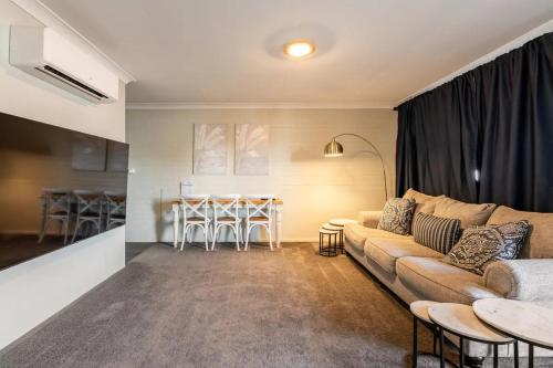 ein Wohnzimmer mit einem Sofa und einem Tisch in der Unterkunft 549 Luxury Apartments in Hervey Bay