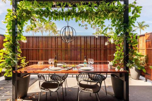 549 Luxury Apartments في خليج هيرفي: طاولة وكراسي خشبية على الفناء