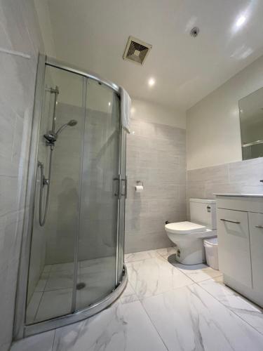 a bathroom with a shower and a toilet at Grand Central Serviced Apartments in Auckland
