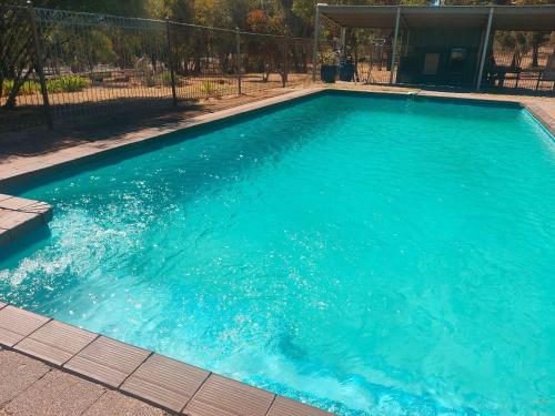 - une grande piscine d'eau bleue dans la cour dans l'établissement Happy Wanderer Holiday Resort The Grampians, à Wartook