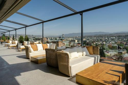 a room with couches and tables on a roof at Castor & Pollux Hotel in Tbilisi City