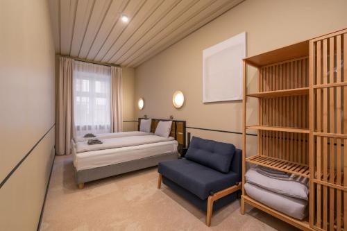une chambre avec un lit et une chaise dans une pièce dans l'établissement Dandelion Apartments Lāčplēša, à Riga
