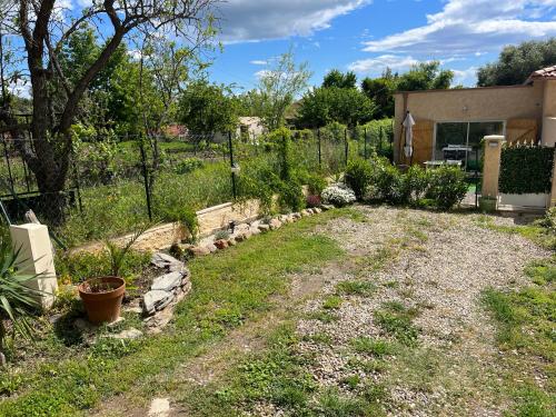 a garden with a fence and some plants in a yard at Studio tout équipé à la nuitée ou plus,proche aéroport Bastia in Lucciana