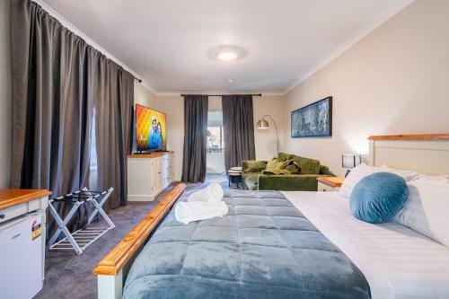 1 dormitorio con 1 cama grande y sala de estar en Cypress BnB en Hervey Bay