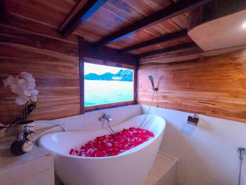 y baño con bañera llena de pimientos rojos. en DAV Travels, en Labuan Bajo