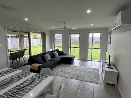 a living room with a couch and a table at Beautiful 4 bdr house - Sandstone point, Bribie in Sandstone Point
