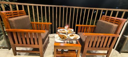 a table with plates of food and a candle on a balcony at Munnar ethan's valley in Anachal