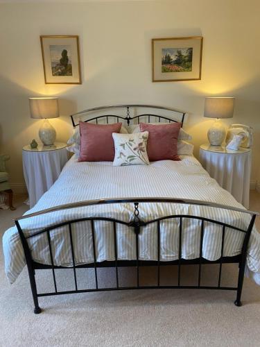 Un dormitorio con una cama grande con almohadas. en Lower Farm Cottage en Beaminster