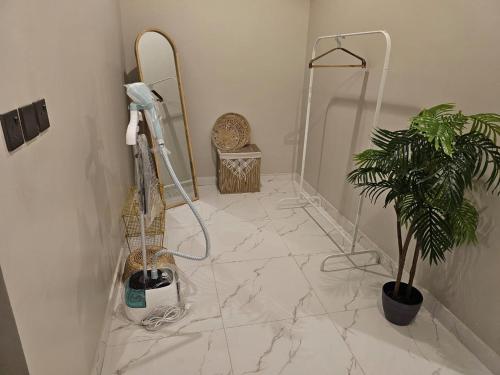 a bathroom with a white marble floor with a plant at استديو انيق وراقي in Riyadh