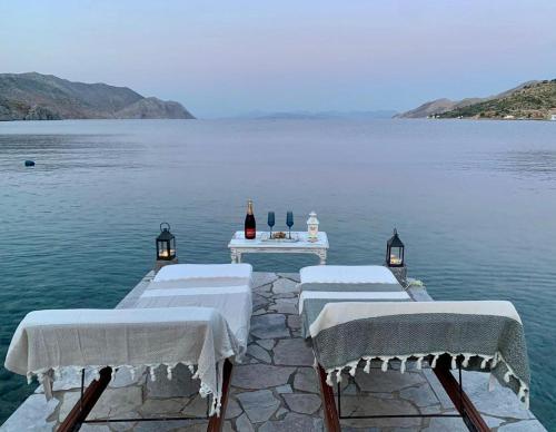 a group of tables on a dock in the water at Symi . VILLA CALME (Sur la Mer). in Symi