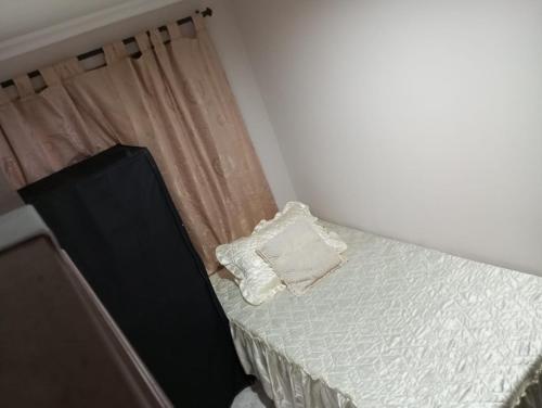 a small bedroom with a bed with a curtain at Habitación # 1 Moderna y Cómoda in Bello