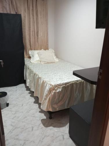 a small bed with white sheets in a room at Habitación # 1 Moderna y Cómoda in Bello